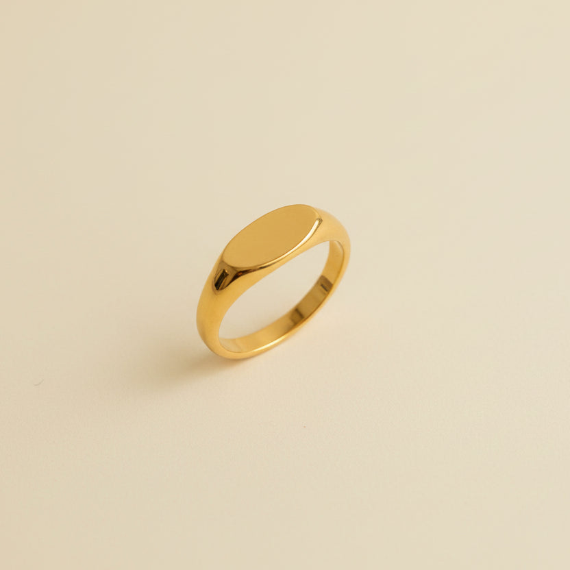 Gold ring with a star design on a beige jewelry box
