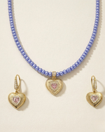 Blue Jewelry set with pink heart-shaped pendants on a light background