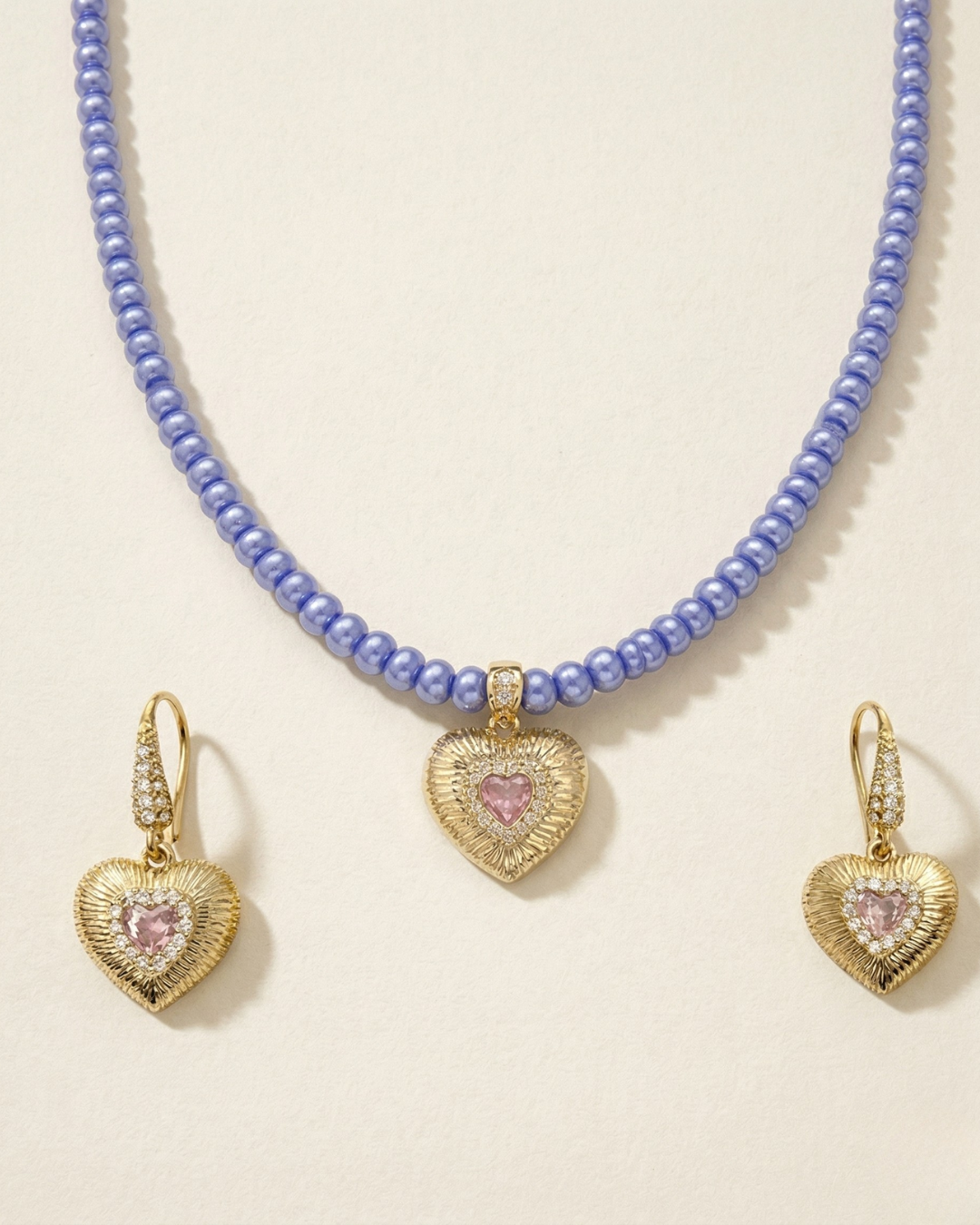 Blue Jewelry set with pink heart-shaped pendants on a light background