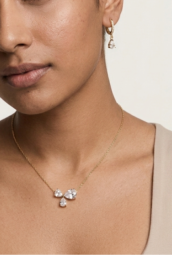 Woman wearing a necklace and earrings on a plain background