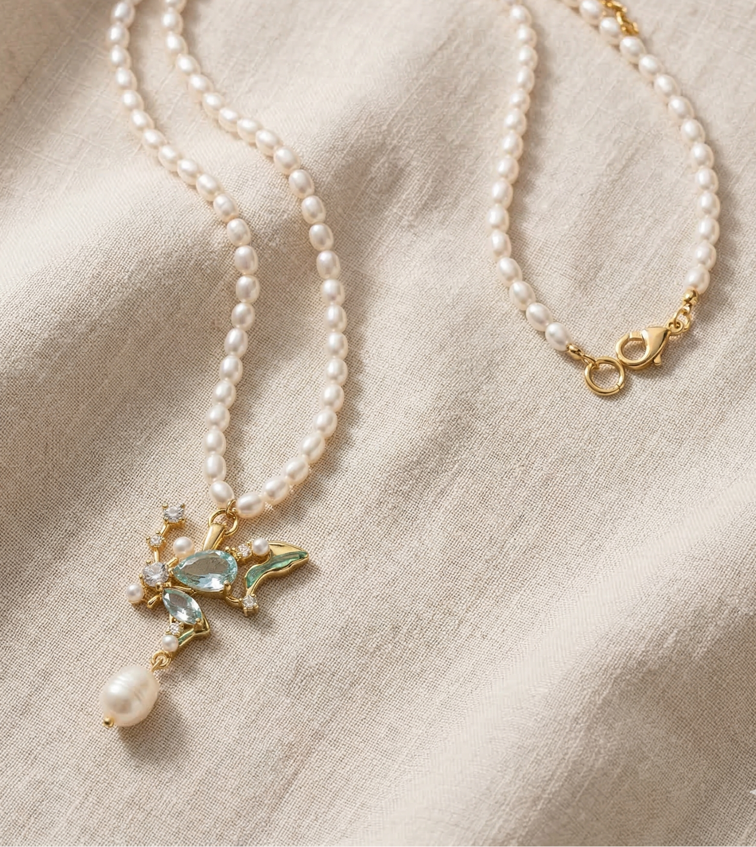 Pearl necklace with a decorative pendant on a beige fabric background