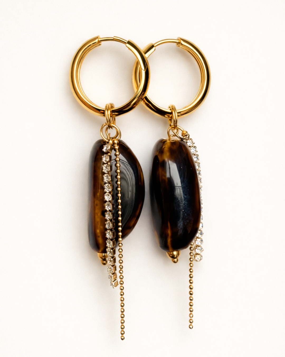 Gold hoop earrings with stones and chain drops on a white background