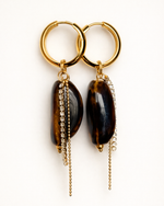 Gold hoop earrings with stones and chain drops on a white background