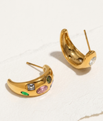 Gold hoop earrings with colorful gemstones on a white background