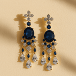 Elegant blue and gold earrings with 'FORAMOUR' branding on a beige background