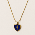 Necklace with a blue shield-shaped pendant on a light beige background