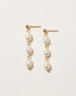 Pair of pearl earrings on a light beige background