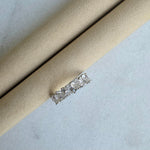 Diamond ring on a light brown cylindrical object against a light gray background
