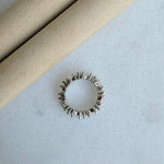Silver ring with geometric design on a light gray surface