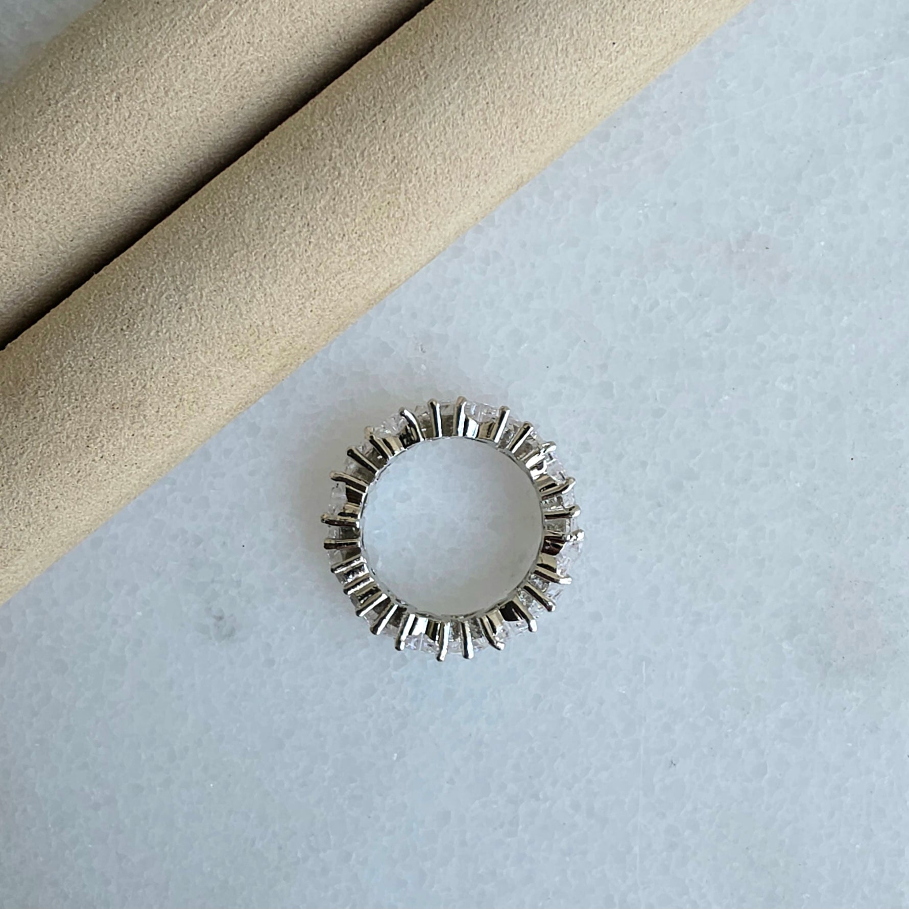 Silver ring with geometric design on a light gray surface