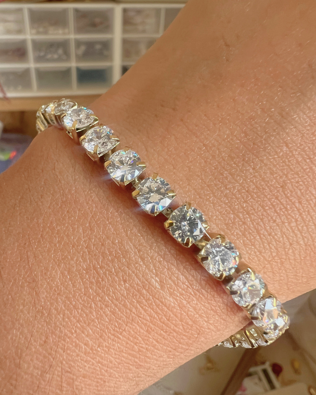 Gold bracelet with large diamonds on a wrist, blurred background