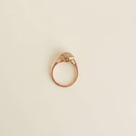 Gold ring with a diamond-like center on a light gray surface