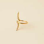 Gold ring with a unique design on a light gray background