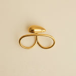Gold hair clip on a light gray textured background