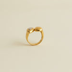 Gold ring with a diamond on a light gray background