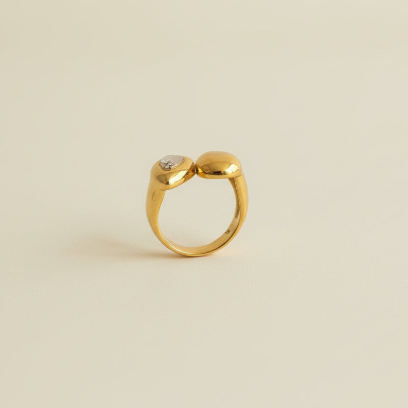 Gold ring with a diamond on a light gray background