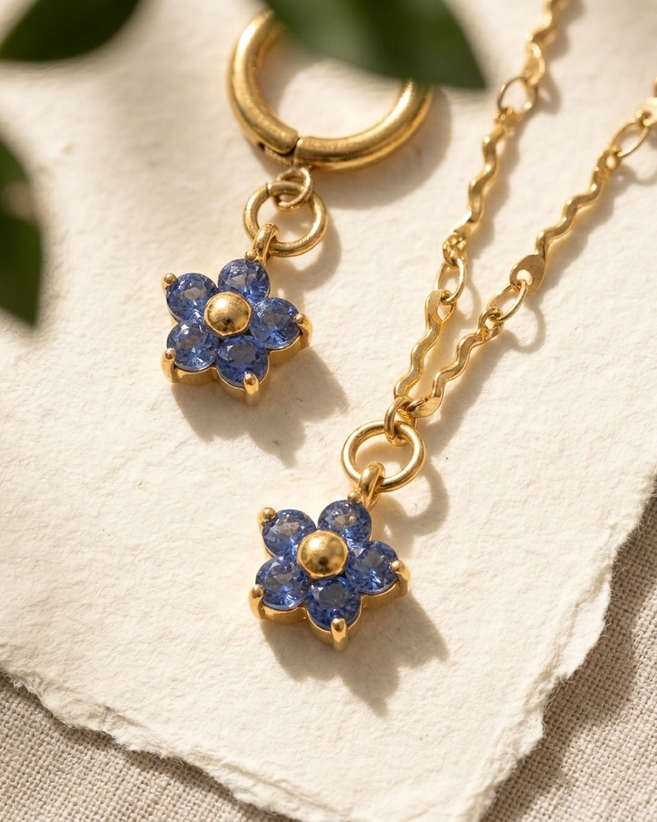 Gold necklace with blue flower pendants on a textured surface