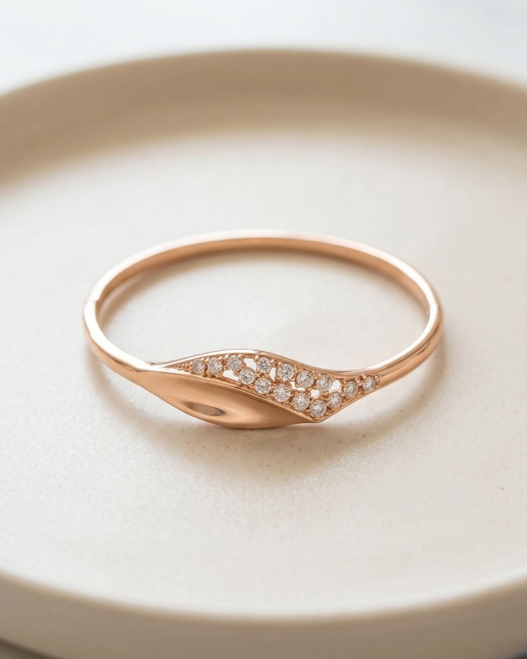 Rose gold ring with diamond accents on a light beige plate
