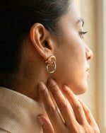 Close-up of a woman wearing a gold earring with a blurred background