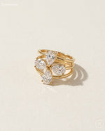 Gold ring with diamond-like stones on a beige background
