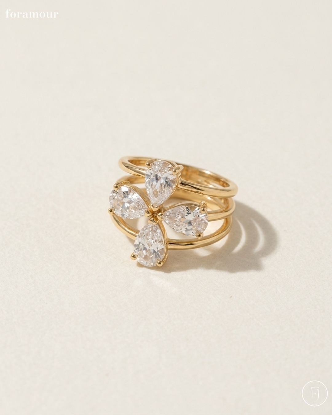Gold ring with diamond-like stones on a beige background