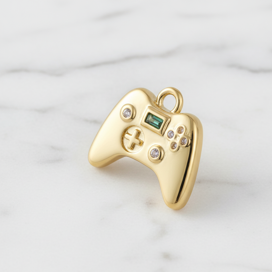 Gold game controller pendant with gemstones on a marble background