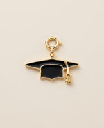 Graduation cap charm on a beige background