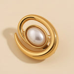 Gold brooch with a pearl on a beige background