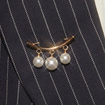 Pearl brooch on a black pinstripe suit jacket
