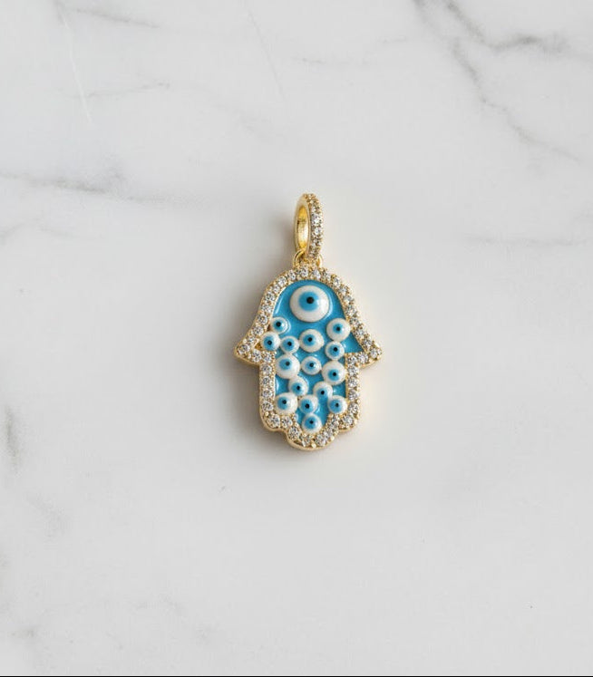 Gold and blue evil eye pendant on a marble background