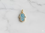 Gold and blue evil eye pendant on a marble background