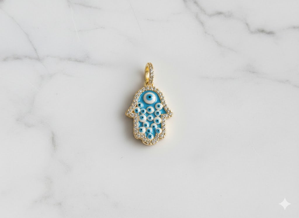 Gold and blue evil eye pendant on a marble background