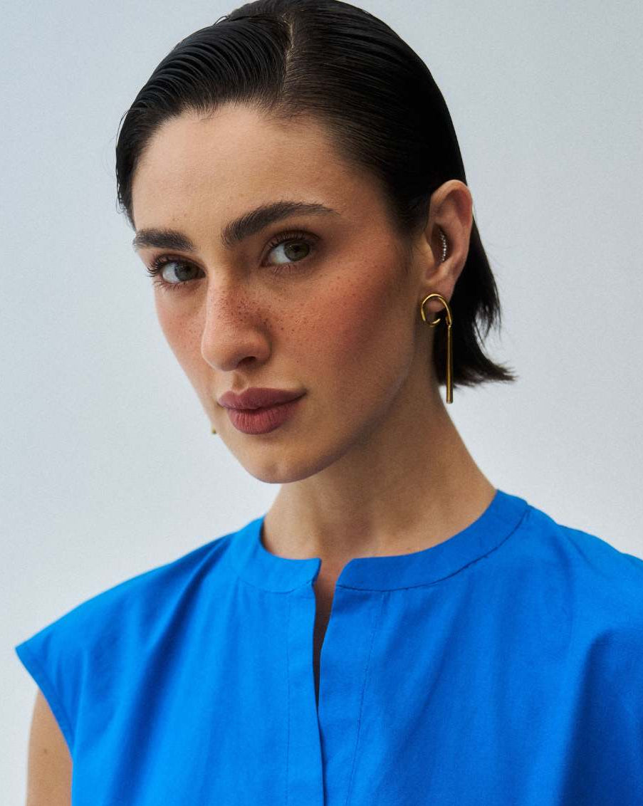 Woman wearing a blue top against a plain background