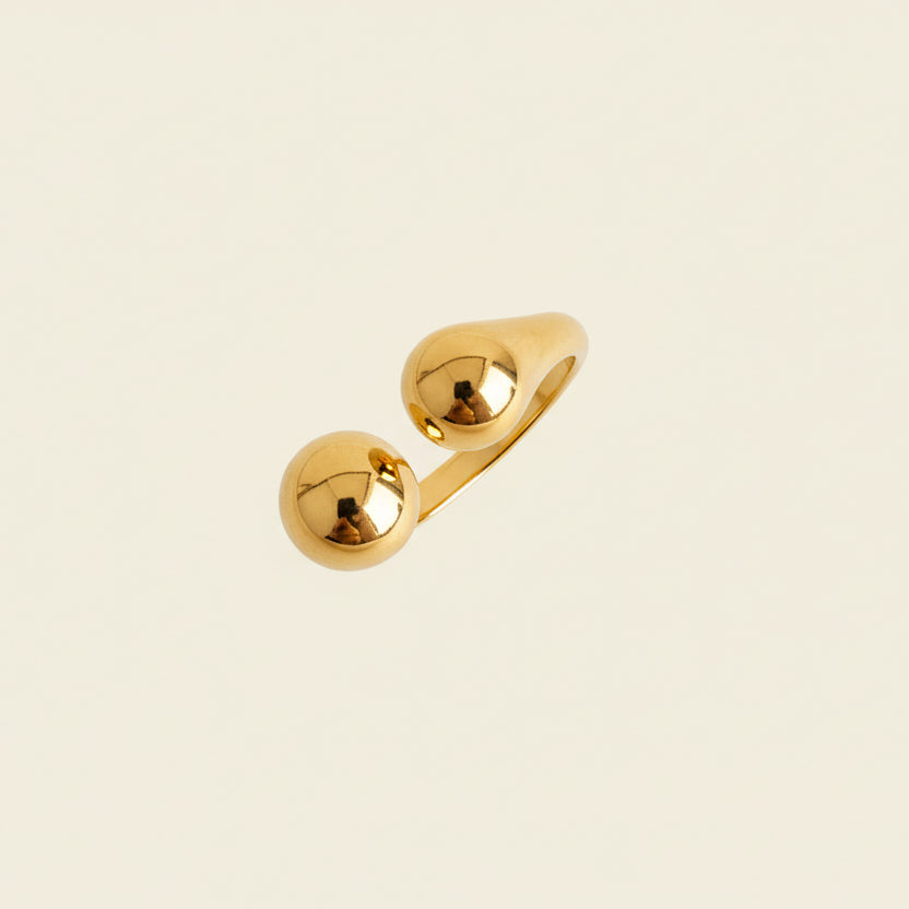 Gold ring on a textured beige surface