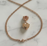 Rose gold heart-shaped pendant necklace on a marble surface