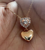 Gold necklace with heart-shaped pendant on a hand