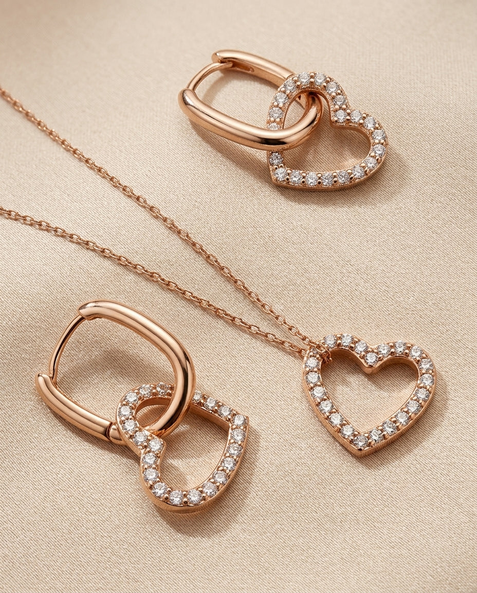 Rose gold heart-shaped jewelry set on a beige fabric background