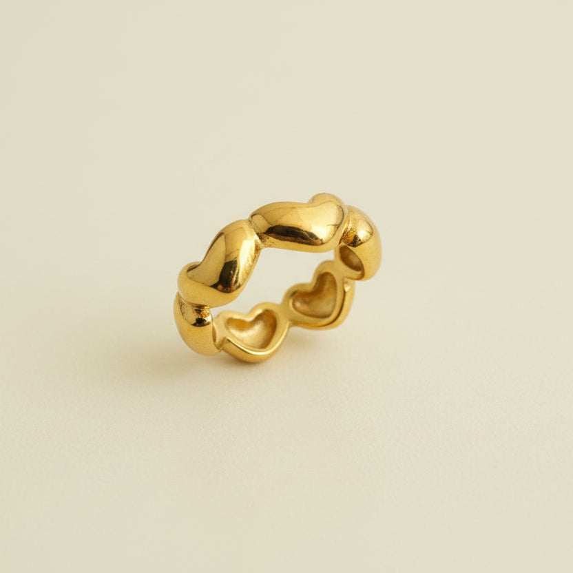 Gold earring on a beige jewelry display box with a white background