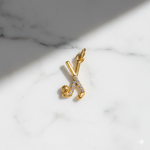 Gold pendant with hockey sticks on a marble surface