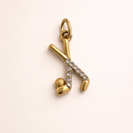Gold and diamond charm on a beige background