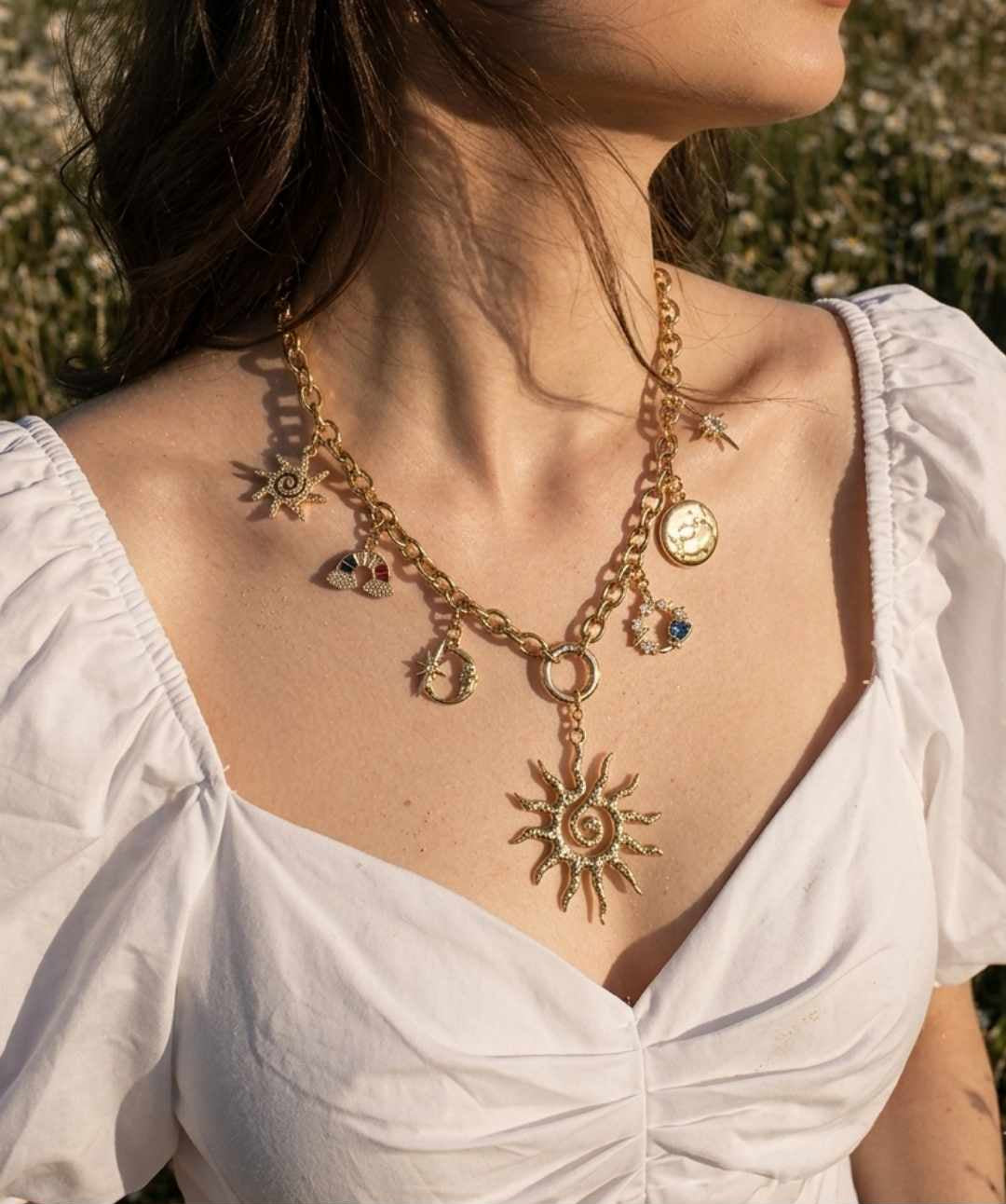 Woman wearing a gold necklace with sun pendant in an outdoor setting