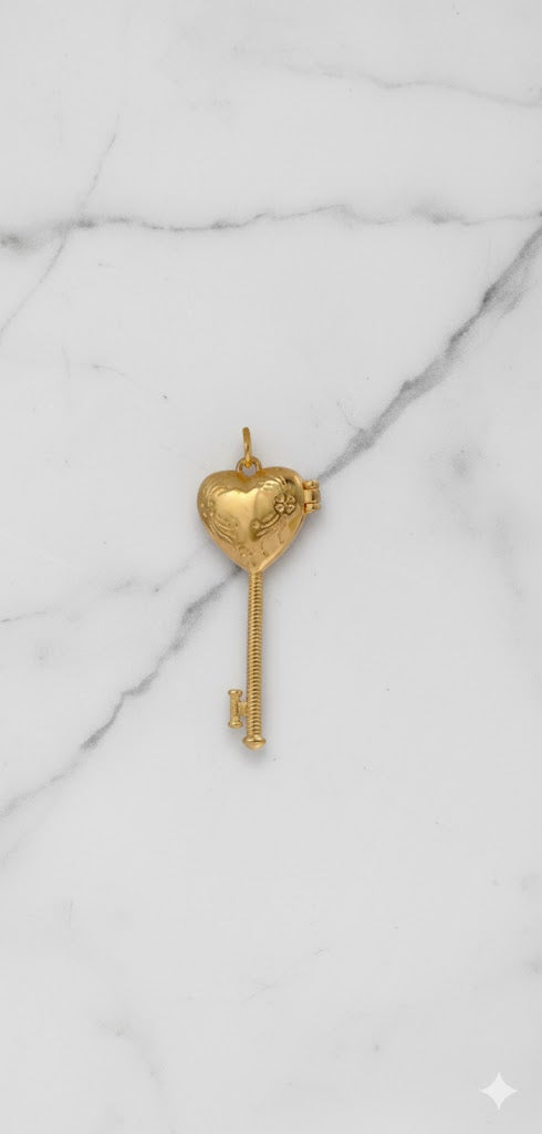 Gold key-shaped pendant on a marble background