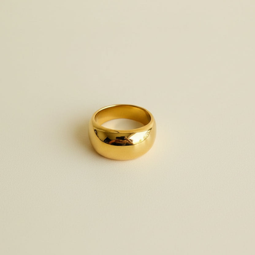 Gold ring with a white label on a light gray surface