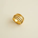 Gold ring on a light beige surface