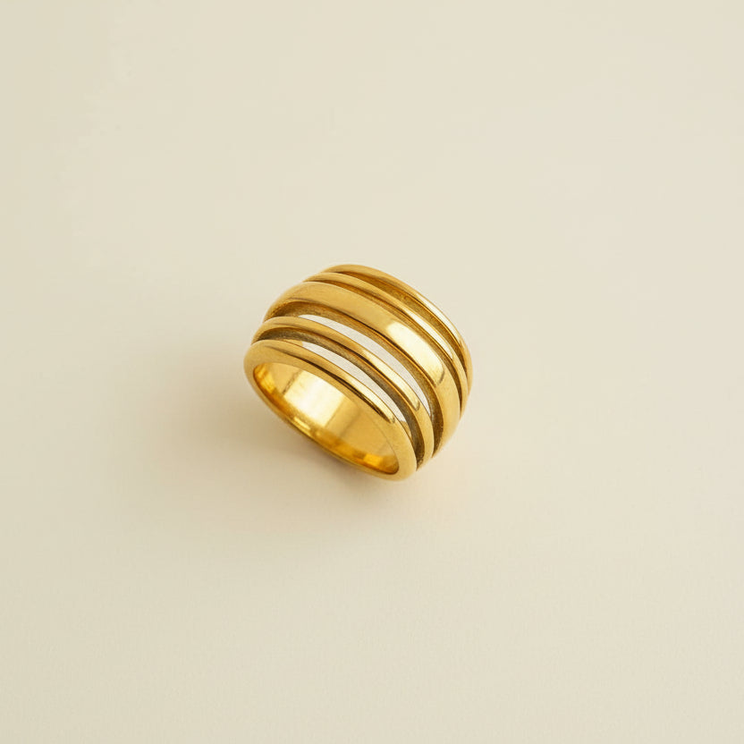 Gold ring on a light beige surface
