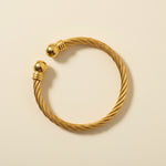 Gold bracelet on a light gray background