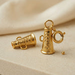 Gold megaphone charm on a beige background