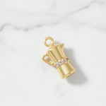 Gold charm shaped like a pitcher with a handle on a white background