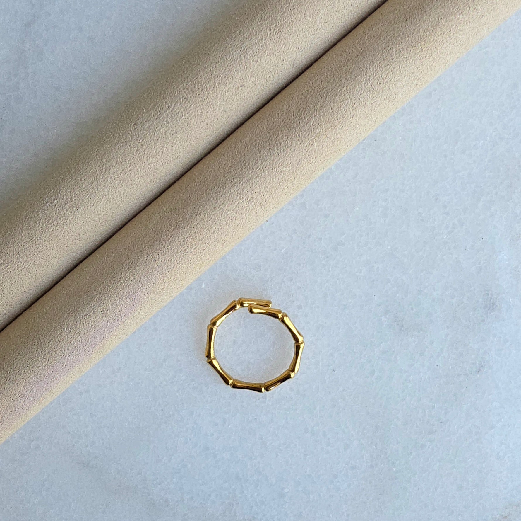 Gold hexagonal ring on a light gray surface
