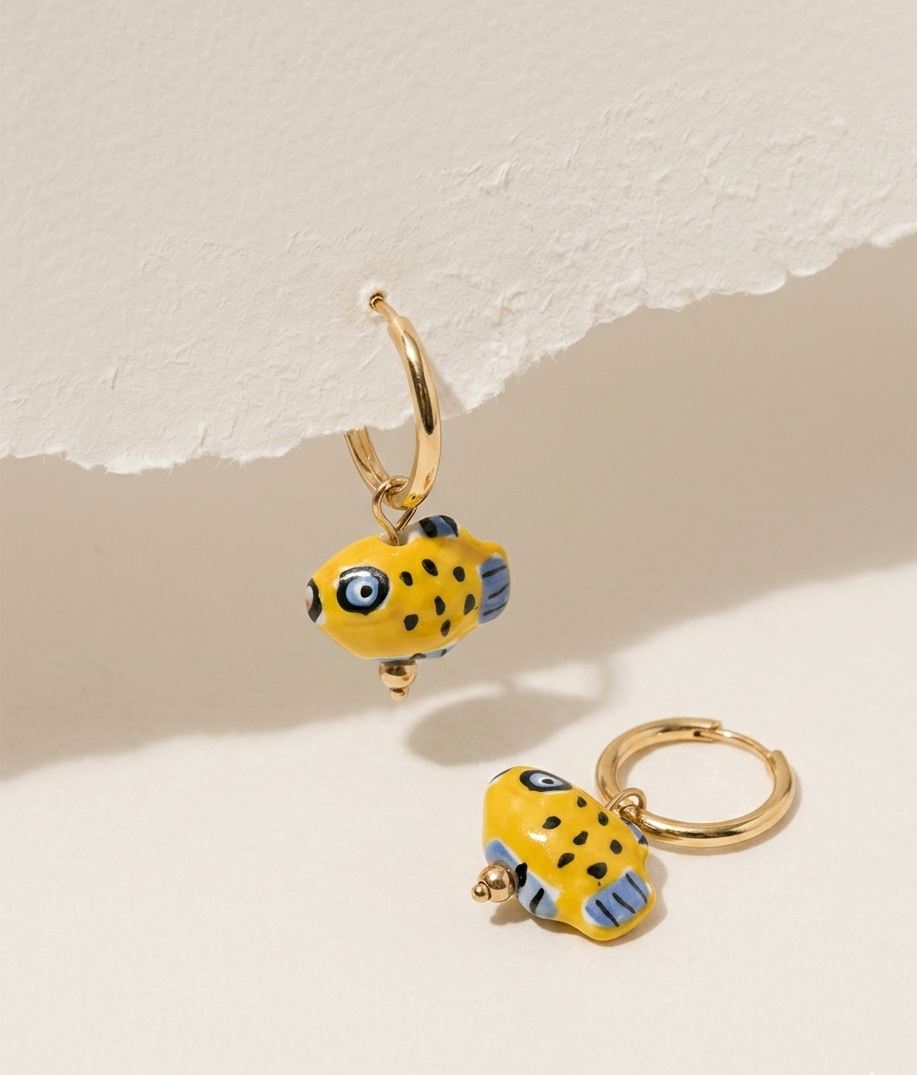 Yellow fish-shaped earrings on a light background